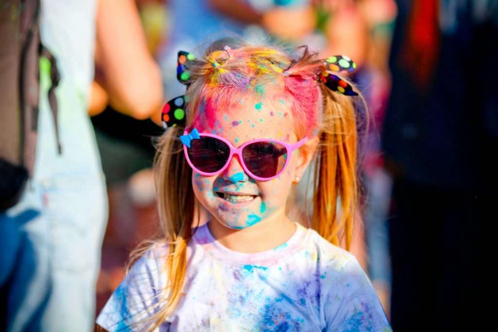 Child in green colors Holi. Holi facial shot on spring color festival of Holi.